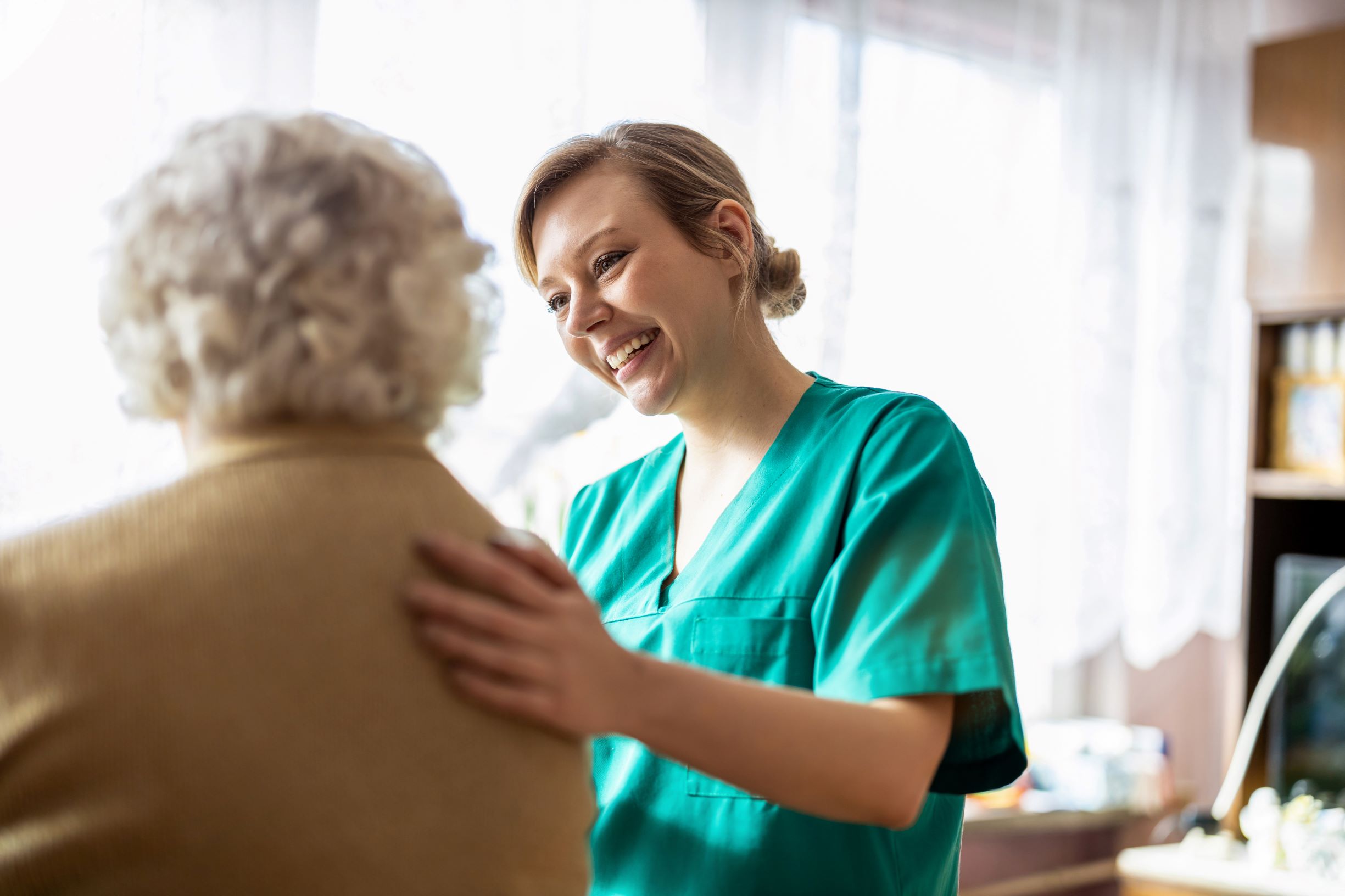 Domiciliary carer speaking with the lady she is caring for