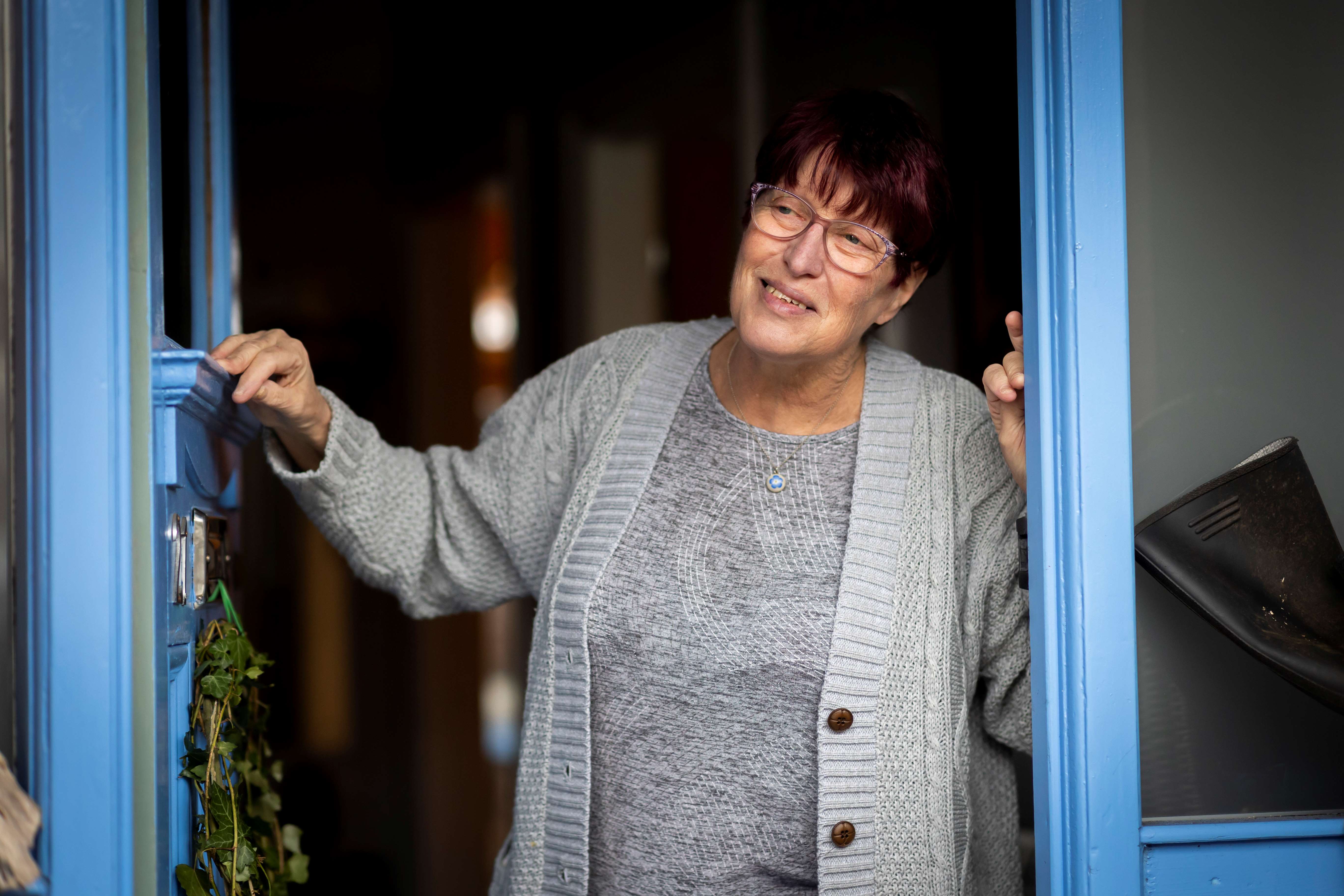 Lady standing at her open front door