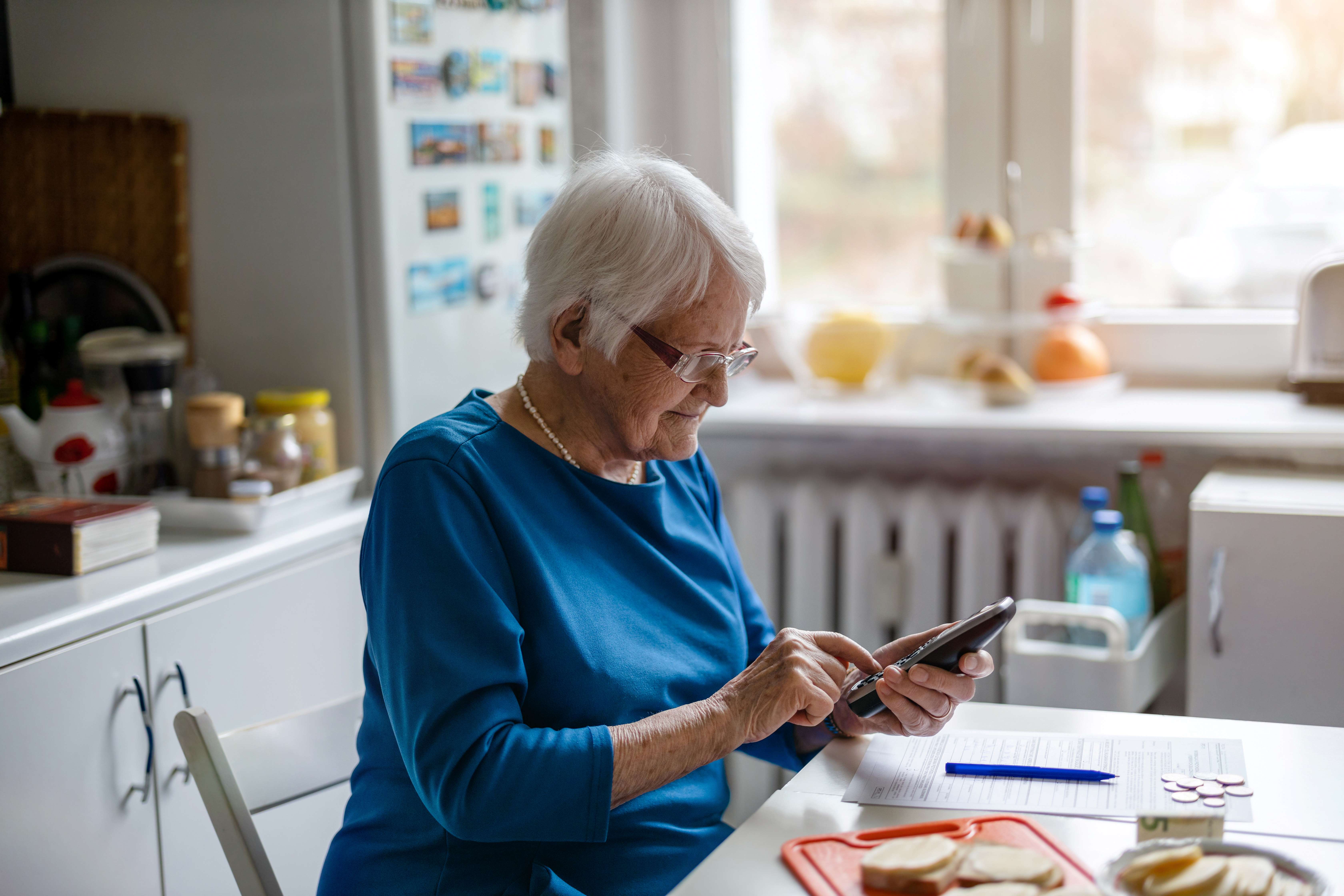 Lady sitting at the dining table using the phone