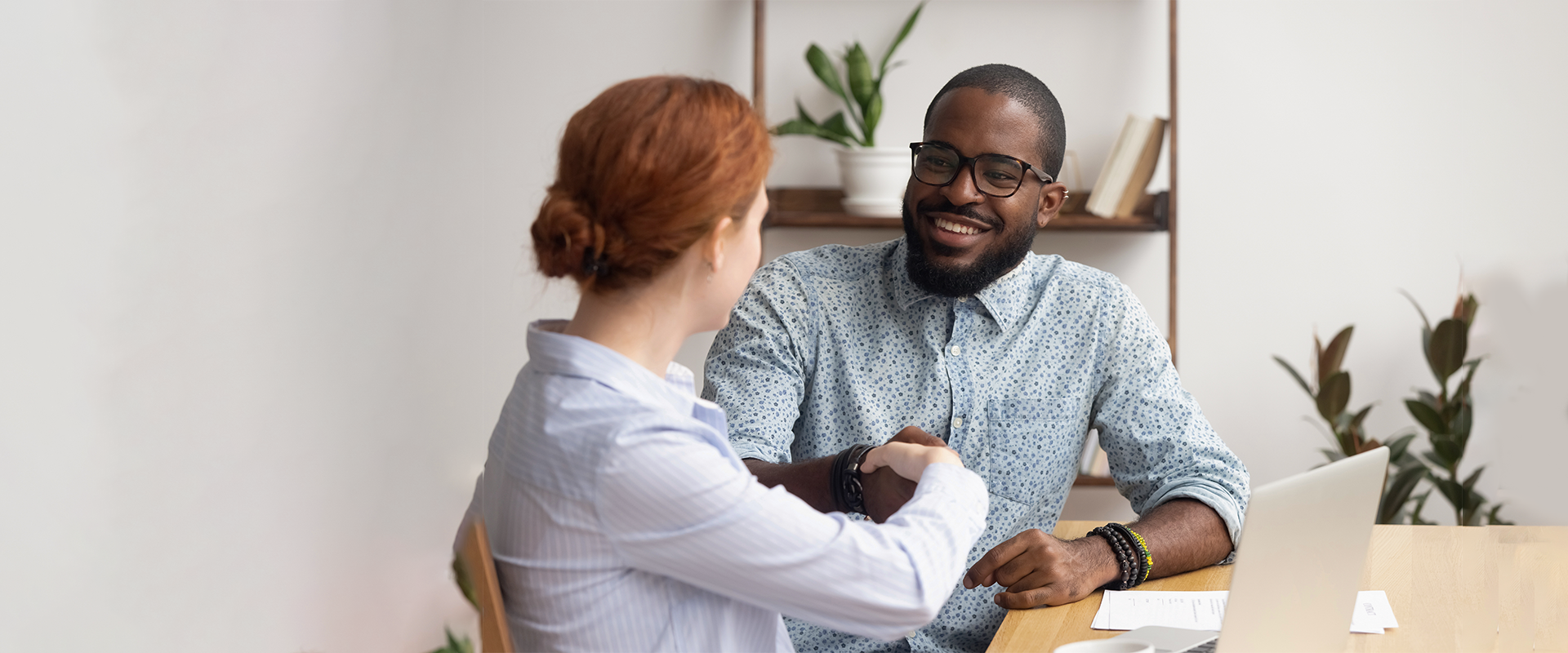 Man smiling and shaking hands with interviewer