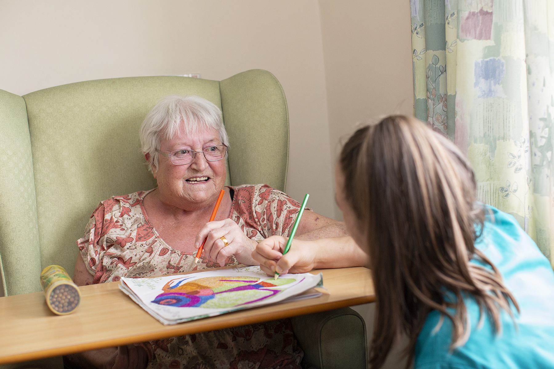 Resident drawing with carer at Picton Court Care Home